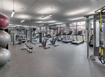 a large fitness room with cardio equipment and weights